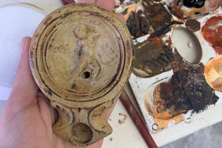 Lea Milančec, stručnjakinja za restauraciju keramike, prikazana dok precizno retušira keramičku uljanicu tijekom procesa restauracije.